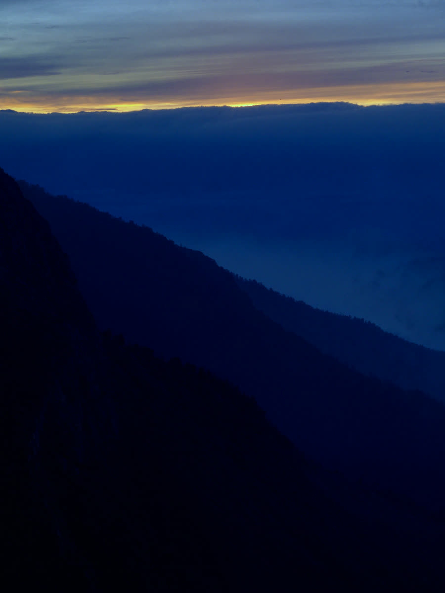 Misty mountain ridge at dusk with warm rim light